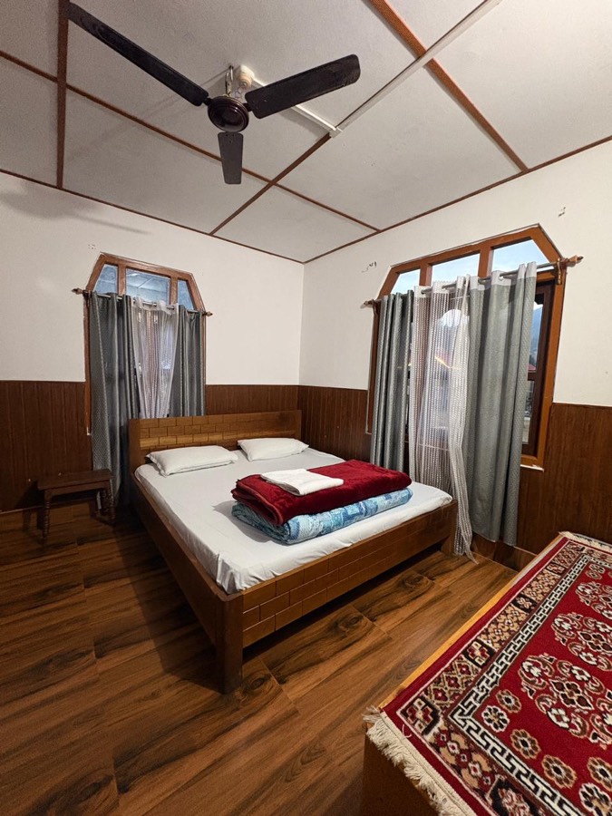 Warm bedroom interior with wooden flooring at Phuntso River Cottages