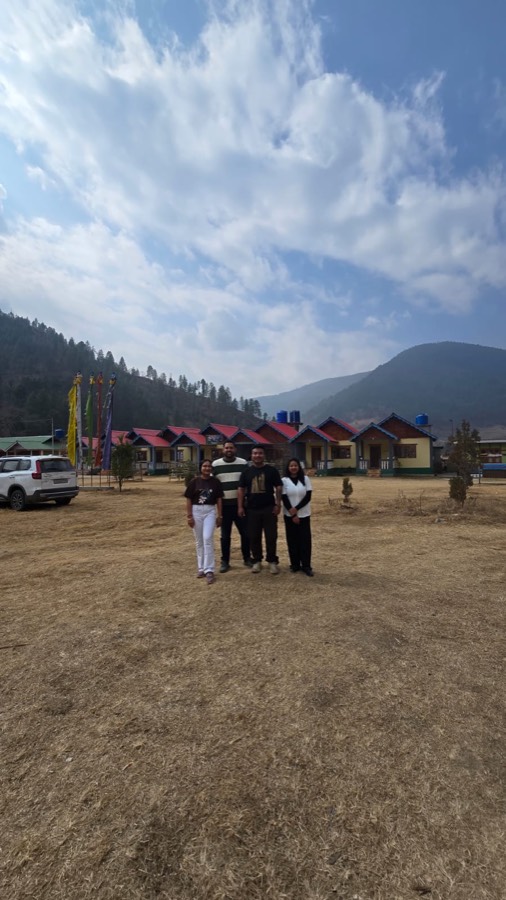 Guests standing on the open lawn with cottages and mountain views behind them