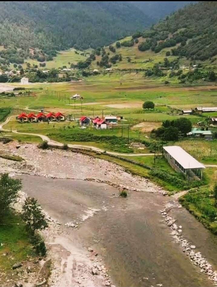 Wide view of the river, meadows, and cottages in Sangti Valley near Dirang